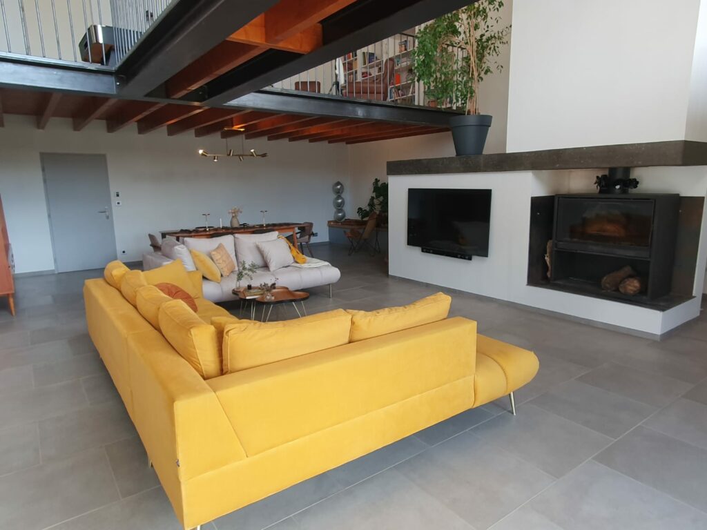 Salon du gîte en Ariège avec passerelle au style industriel, canapés confortables et décoration moderne à Mirepoix