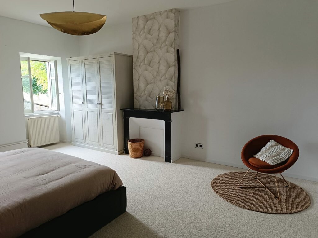 Vue de la chambre avec armoire et fauteuil