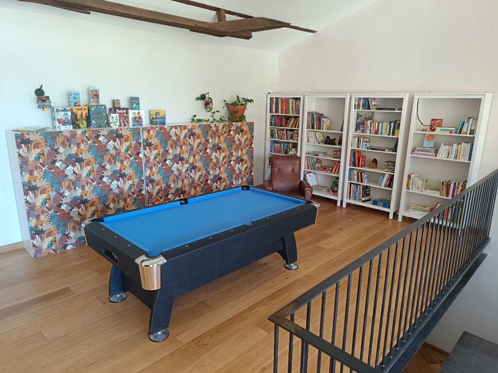 Mezzanine du gîte en Ariège avec espace détente, billard et bibliothèque, idéale pour les séjours à Mirepoix