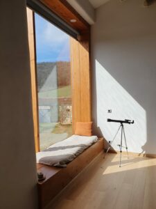 Grande baie vitrée donnant sur la piscine et le paysage naturel du Domaine Monbel en Ariège