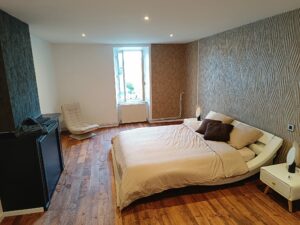 Chambre du gîte en Ariège avec lit double, ambiance sobre et confortable pour un séjour au calme.