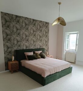 Chambre lumineuse du gîte en Ariège avec lit double et vue sur la nature.