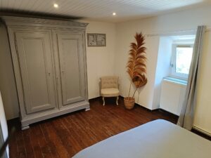 Chambre du gîte en Ariège avec lit double et décoration cosy, idéale pour un séjour reposant à la campagne.