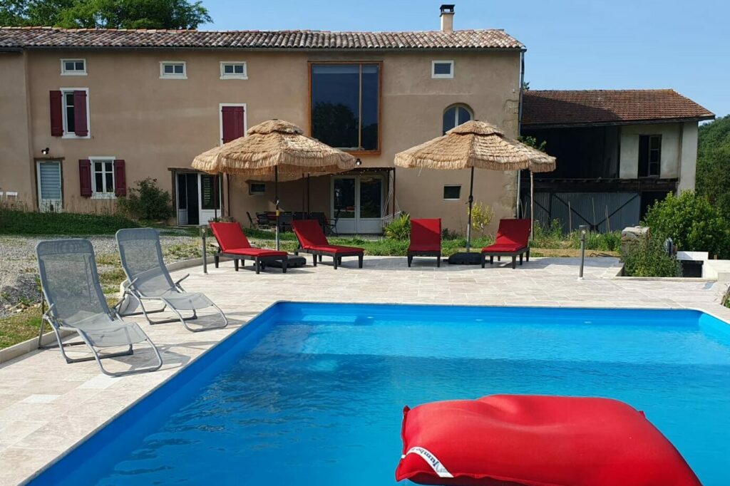 Piscine extérieure du gîte en Ariège, entourée d’un jardin verdoyant, idéale pour se rafraîchir en été.