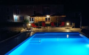 Piscine du gîte en Ariège éclairée la nuit, ambiance chaleureuse et reposante près de Mirepoix