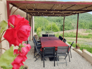 Terrasse extérieure aménagée avec une grande table pour 12 personnes à la ferme Monbel en Ariège